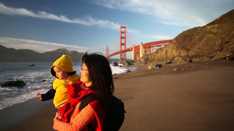 Mother and child on a beach below the Golden Gate Bridge in San Francisco, California Mother and child on a beach below the Golden Gate Bridge in San Francisco, California