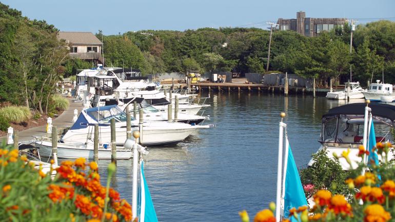 Wooden boardwalks lined with trees wind throughout the intimate beach communities of Cherry Grove and The Pines on Fire Island. Wooden boardwalks lined with trees wind throughout the intimate beach communities of Cherry Grove and The Pines on Fire Island.