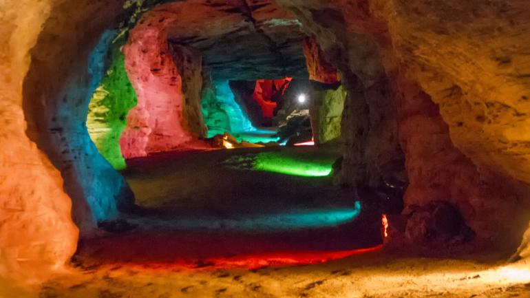 Multicolored lights illuminate the passages within Laurel Caverns Multicolored lights illuminate the passages within Laurel Caverns