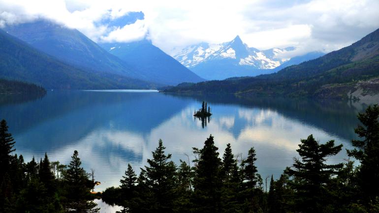 The big (and ever-changing) skies of Glacier National Park reflected in a glacial lake The big (and ever-changing) skies of Glacier National Park reflected in a glacial lake