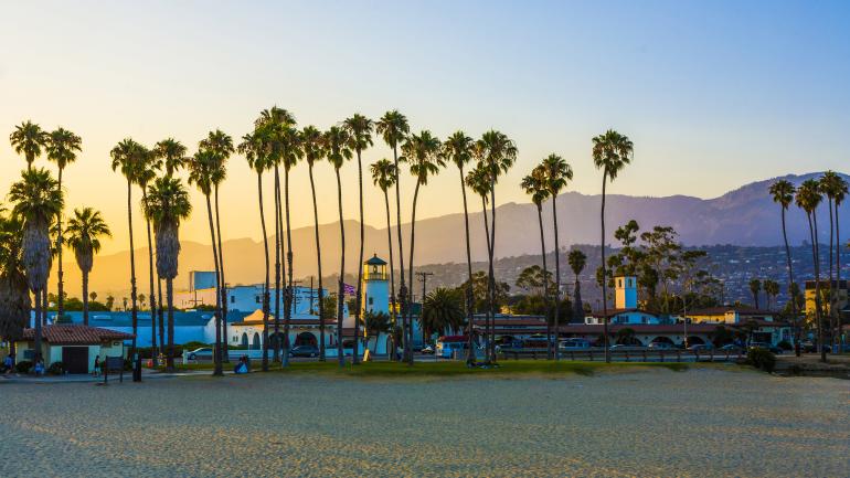 An idyllic beach scene at sunset including Santa Barbara’s promenade and mountains An idyllic beach scene at sunset including Santa Barbara’s promenade and mountains