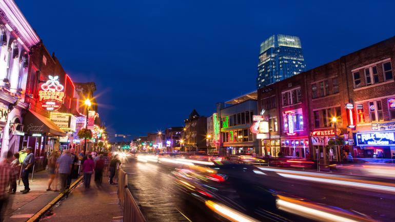 Enjoying the shops, bars and restaurants of busy downtown Nashville, Tennessee, as traffic zooms by on the street Enjoying the shops, bars and restaurants of busy downtown Nashville, Tennessee, as traffic zooms by on the street