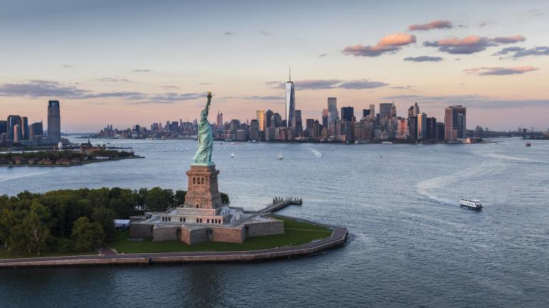 La statue de la Liberté se découpe sur la ligne d’horizon de New York La statue de la Liberté se découpe sur la ligne d’horizon de New York