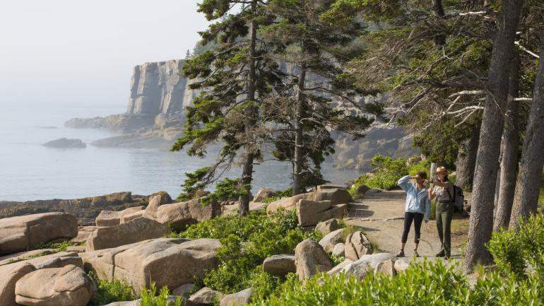 Hiker and park ranger on a scenic trail in Acadia National Park Hiker and park ranger on a scenic trail in Acadia National Park