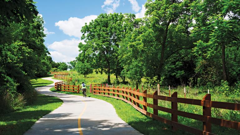 A road cyclist winds along the Razorback Regional Greenway A road cyclist winds along the Razorback Regional Greenway