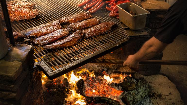 Grilling meats low and slow over a flame at The Salt Lick BBQ Grilling meats low and slow over a flame at The Salt Lick BBQ