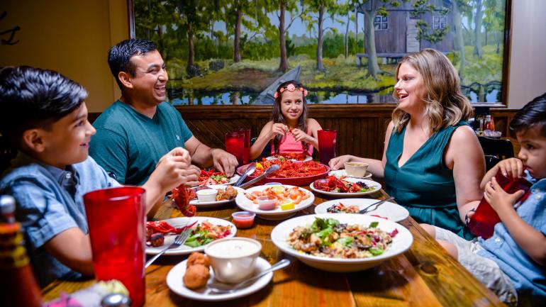 Family sharing a meal of fresh, local shrimp and crawfish in Lake Charles, Louisiana Family sharing a meal of fresh, local shrimp and crawfish in Lake Charles, Louisiana