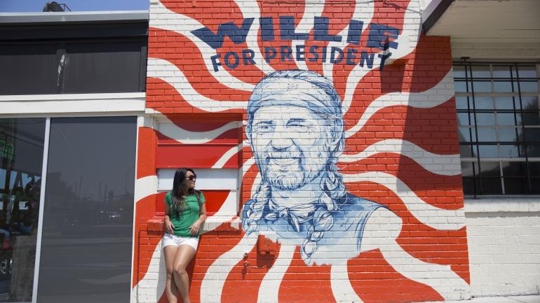 Posing with a mural celebrating Willie Nelson in Austin Posing with a mural celebrating Willie Nelson in Austin