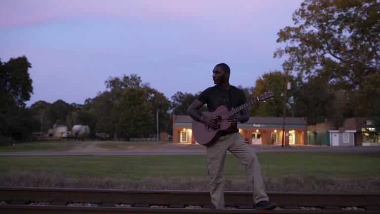 Cedric Burnside with his guitar on a Jackson evening Cedric Burnside with his guitar on a Jackson evening