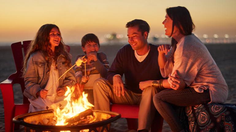Roasting s'mores at a cozy beach bonfire Roasting s'mores at a cozy beach bonfire