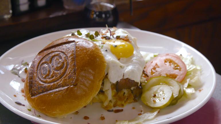 La Brunch Burger, que tiene un huevo frito y papas doradas, en QC Coffee & Pancake House La Brunch Burger, que tiene un huevo frito y papas doradas, en QC Coffee & Pancake House