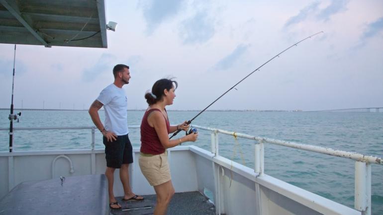 Trying to reel in a big catch on a South Padre Island fishing charter Trying to reel in a big catch on a South Padre Island fishing charter