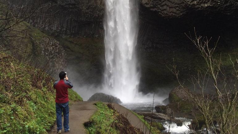 A hiker photographing Latourell Falls A hiker photographing Latourell Falls