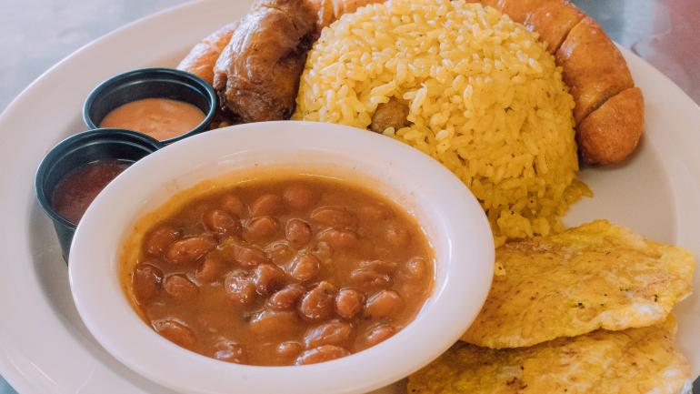Traditional longaniza sausage paired with tostones (fried plantains), beans and rice Traditional longaniza sausage paired with tostones (fried plantains), beans and rice