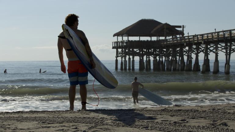 Surfistas listos para montar olas cerca del Cocoa Beach Pier en Florida Surfistas listos para montar olas cerca del Cocoa Beach Pier en Florida