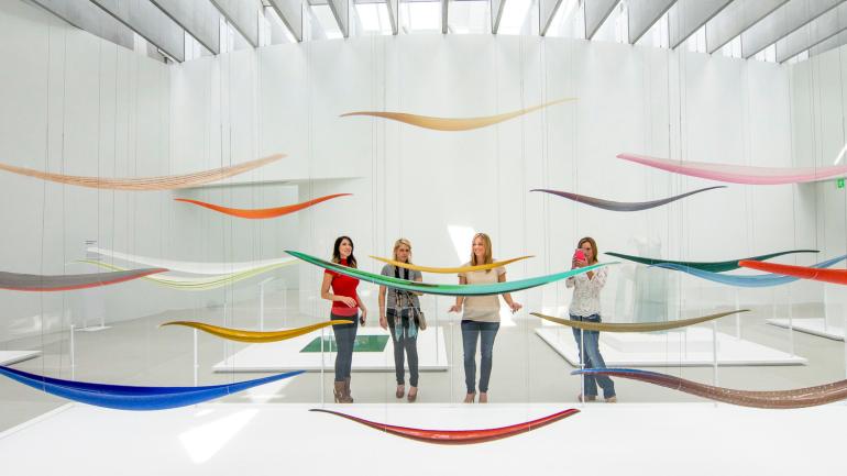 A group of women viewing colorful glass at the Corning Museum of Glass in the Finger Lakes, New York A group of women viewing colorful glass at the Corning Museum of Glass in the Finger Lakes, New York