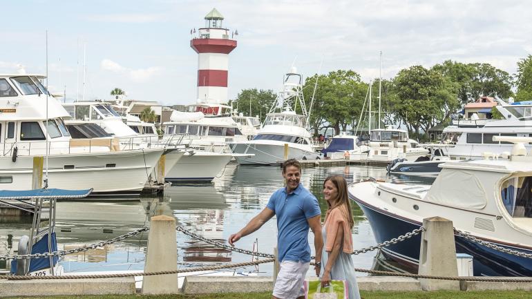 Couple exploring the waterfront near the Harbour Town Lighthouse in Hilton Head Island Couple exploring the waterfront near the Harbour Town Lighthouse in Hilton Head Island