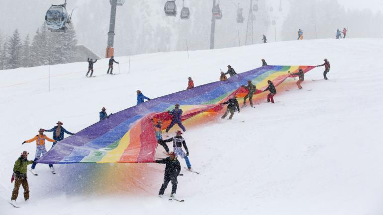 Rainbow Pride Flag being brought down the mountain during Aspen Gay Ski Week in Colorado Rainbow Pride Flag being brought down the mountain during Aspen Gay Ski Week in Colorado