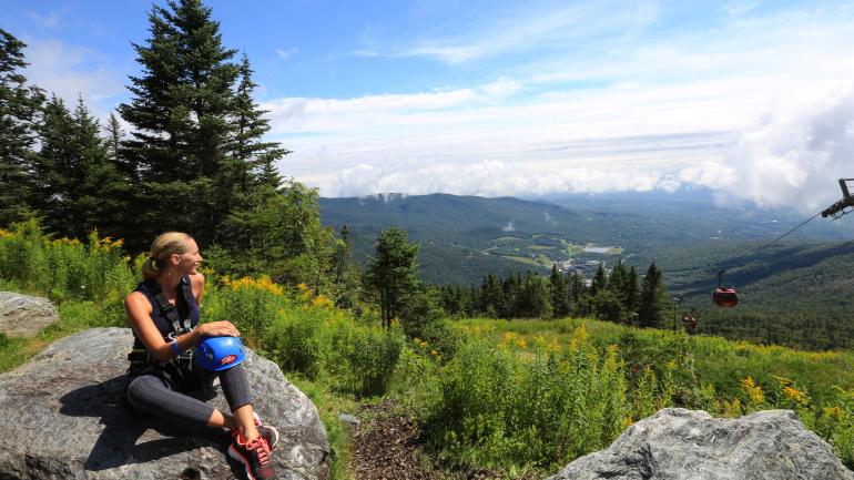 Hiker taking in the views atop Stowe Mountain in Stowe, Vermont Hiker taking in the views atop Stowe Mountain in Stowe, Vermont