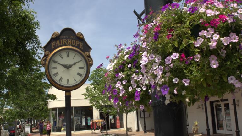 A clock and floral accents on a charming street in Fairhope, Alabama A clock and floral accents on a charming street in Fairhope, Alabama