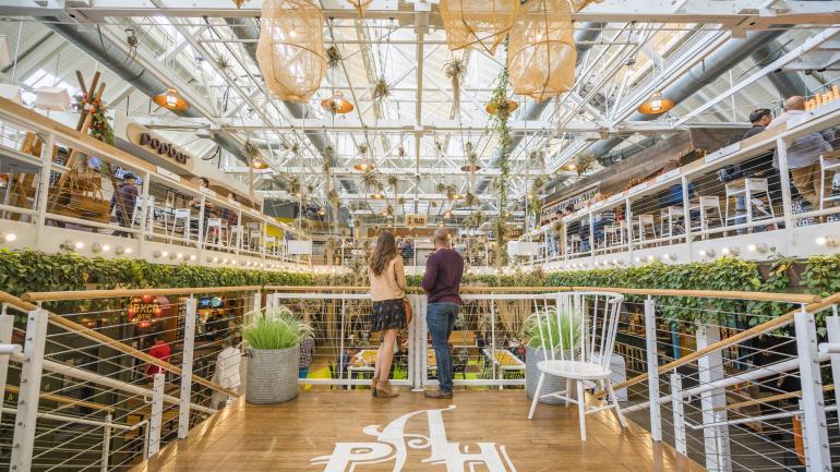 A couple overlooking all the dining options at Anaheim Packing House A couple overlooking all the dining options at Anaheim Packing House