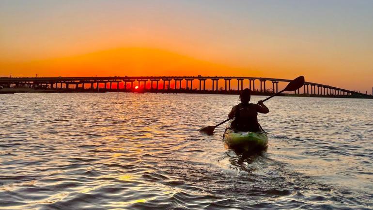 Kayaking in Lake Charles as the sun sets over the Calcasieu River Bridge Kayaking in Lake Charles as the sun sets over the Calcasieu River Bridge