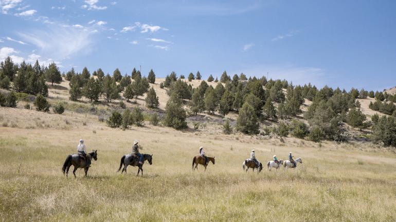 Riding horses on the expansive grounds of Wilson Ranches Retreat in Fossil, Oregon Riding horses on the expansive grounds of Wilson Ranches Retreat in Fossil, Oregon
