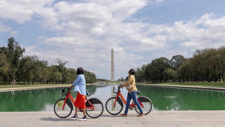 Biking on the National Mall in Washington, D.C., with the Washington Monument in the background Biking on the National Mall in Washington, D.C., with the Washington Monument in the background