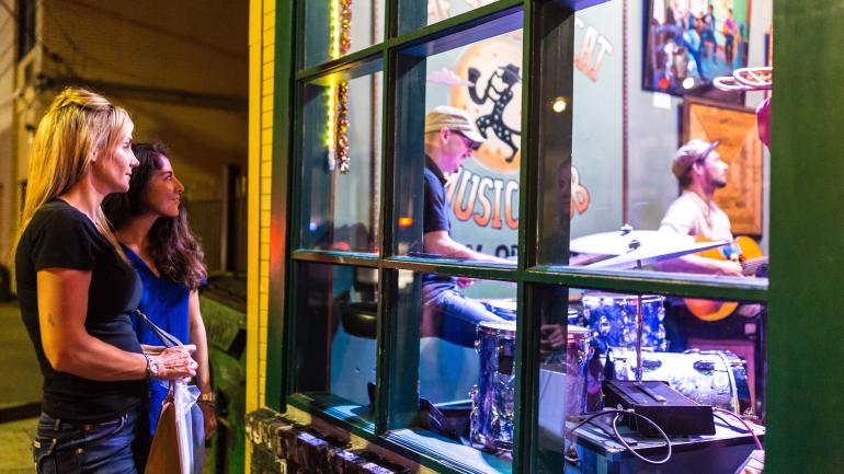 Window shopping for evening entertainment options on Frenchmen Street Window shopping for evening entertainment options on Frenchmen Street