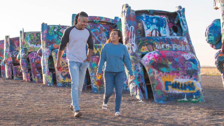 Walking along the half-buried, spraypainted cars of Cadillac Ranch in Amarillo, Texas Walking along the half-buried, spraypainted cars of Cadillac Ranch in Amarillo, Texas