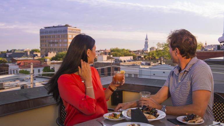 Enjoying a meal with a view at a rooftop restaurant Enjoying a meal with a view at a rooftop restaurant