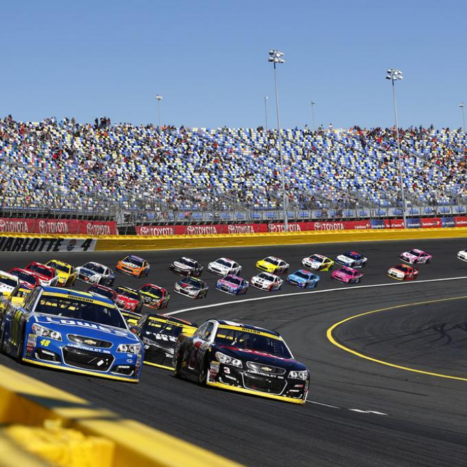 NASCAR cars speed around a track NASCAR cars speed around a track