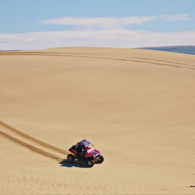 All-terrain vehicle traversing Killpecker Sand Dunes in Wyoming All-terrain vehicle traversing Killpecker Sand Dunes in Wyoming