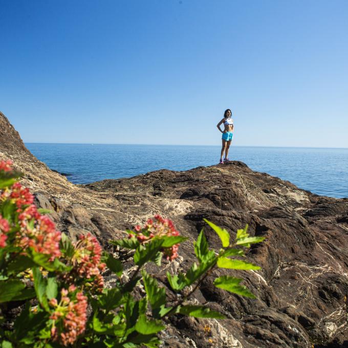 A hiker atop the Black Rocks at Presque Isle Park in Marquette, Michigan A hiker atop the Black Rocks at Presque Isle Park in Marquette, Michigan