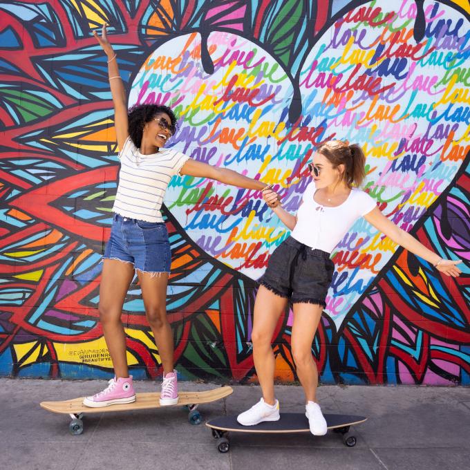 Posing on skateboards with a mural on Main Street in Santa Monica California Posing on skateboards with a mural on Main Street in Santa Monica California