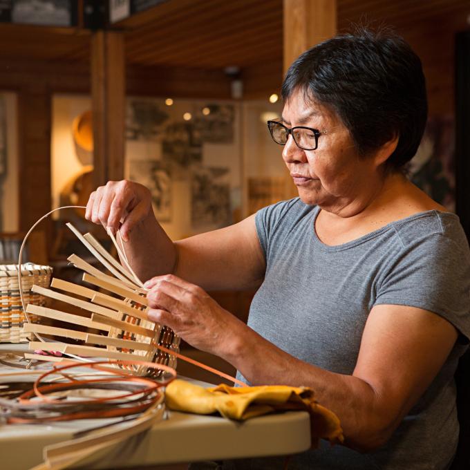 Artesano Cherokee tejiendo una canasta en la Qualla Arts & Crafts Mutual en Cherokee, Carolina del Norte Artesano Cherokee tejiendo una canasta en la Qualla Arts & Crafts Mutual en Cherokee, Carolina del Norte