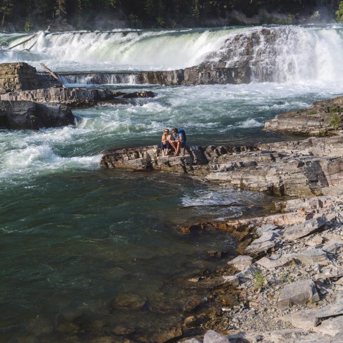 Couple relaxing at Kootenai Falls in Montana Couple relaxing at Kootenai Falls in Montana