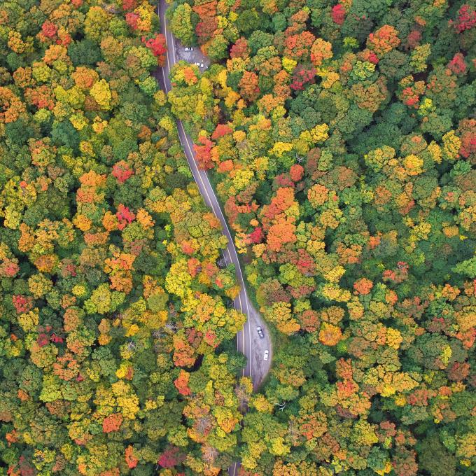 Aerial view of a car driving through Smugglers’ Notch, Vermont, in the fall Aerial view of a car driving through Smugglers’ Notch, Vermont, in the fall
