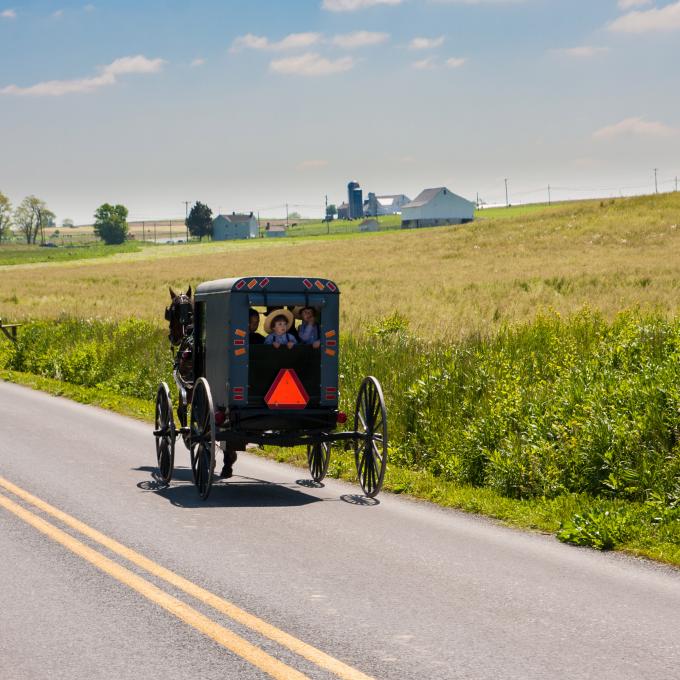 Children peer out the back of a horse-drawn buggy on a rural road in Lancaster, Pennsylvania Children peer out the back of a horse-drawn buggy on a rural road in Lancaster, Pennsylvania