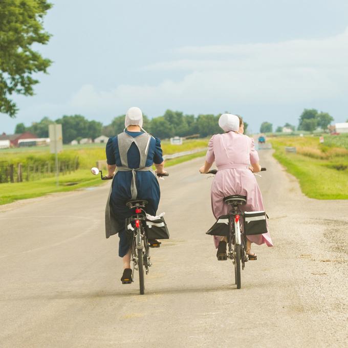 Members of the Amish community in Arthur, Illinois bike through verdant farmlands Members of the Amish community in Arthur, Illinois bike through verdant farmlands