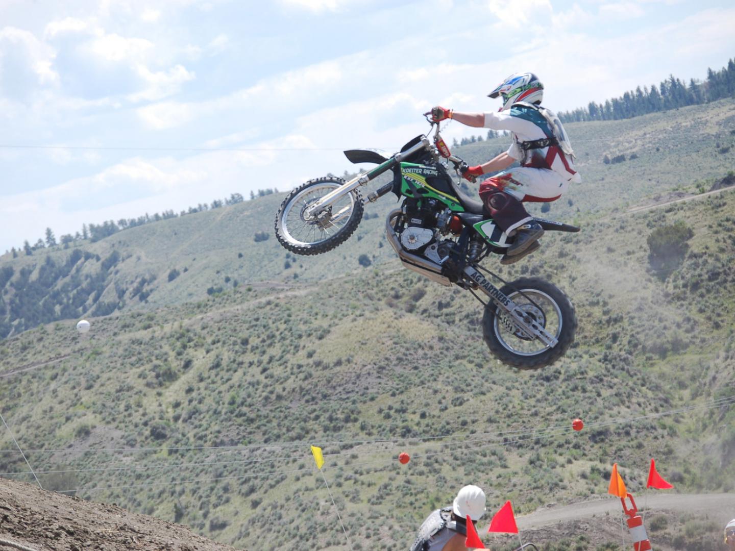 Pilote de motocross en plein saut pendant la course Great American Championship Motorcycle Hill Climb Pilote de motocross en plein saut pendant la course Great American Championship Motorcycle Hill Climb