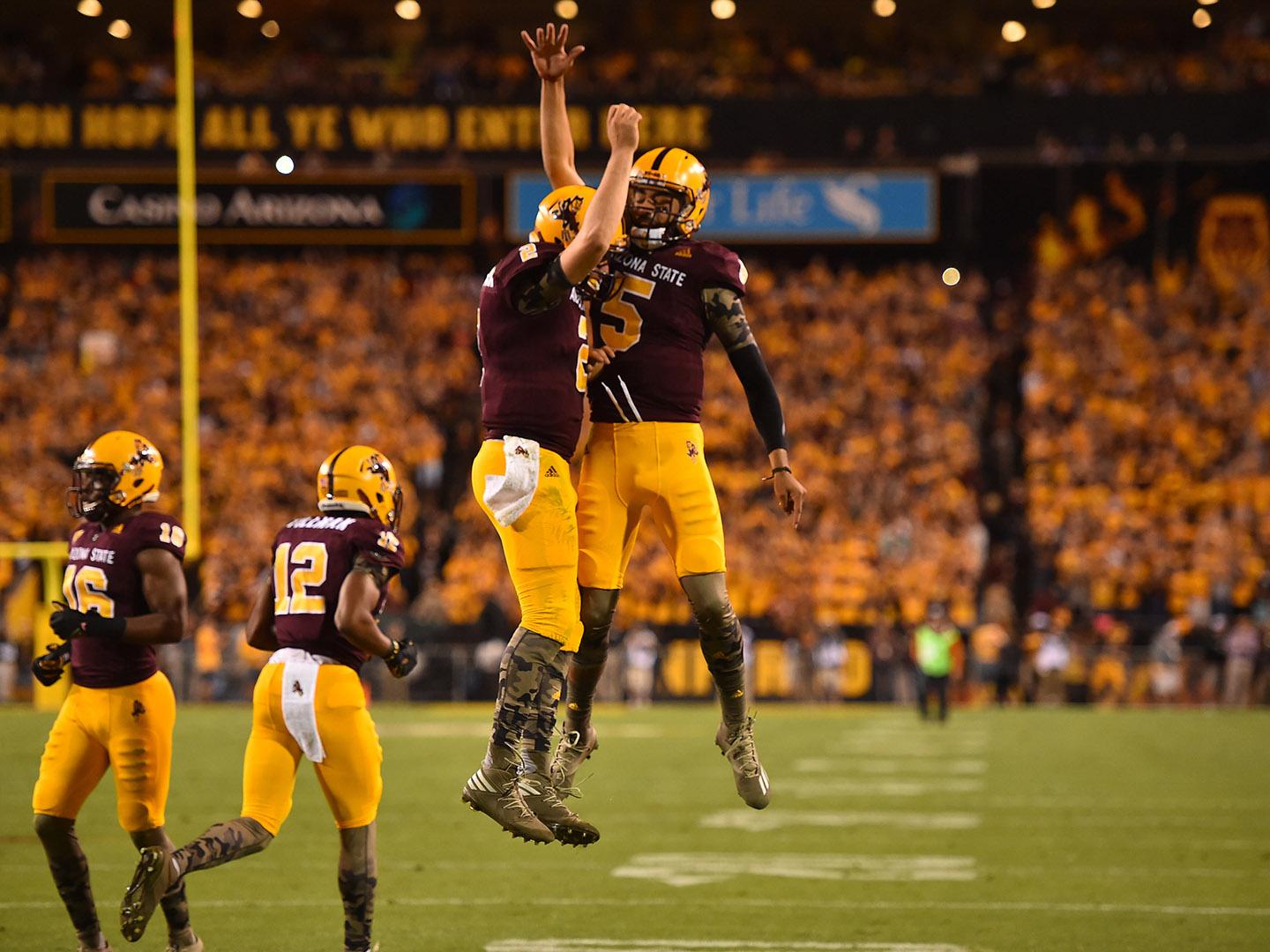 Zwei euphorische Spieler während eines American-Football-Matches der ASU in Tempe, Arizona Zwei euphorische Spieler während eines American-Football-Matches der ASU in Tempe, Arizona