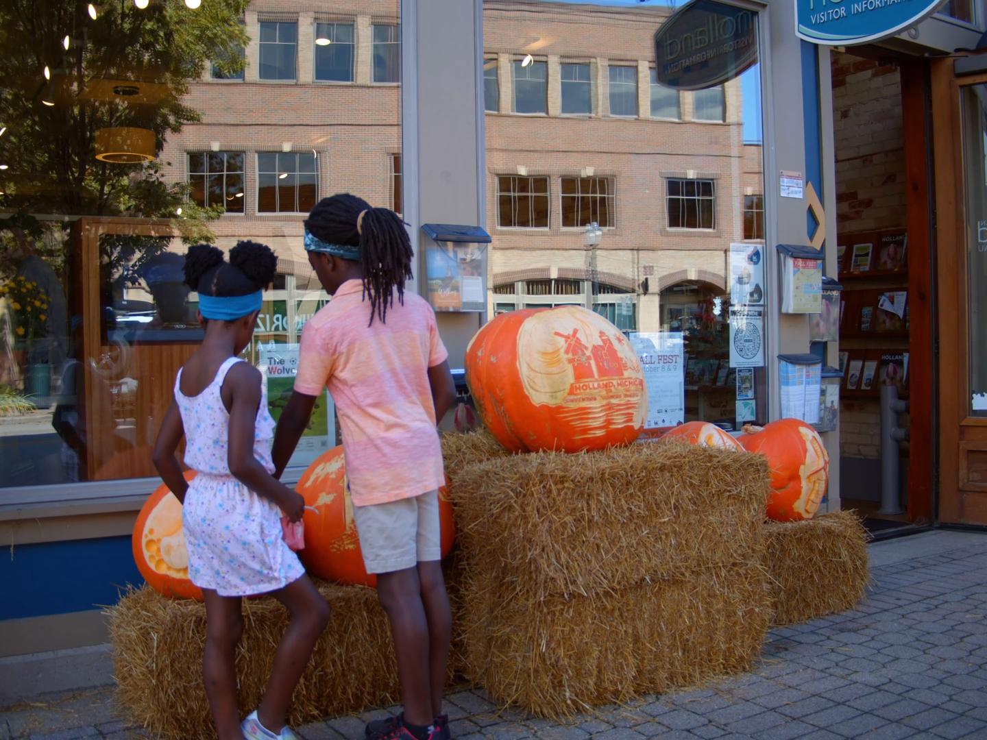 Kinder beim Betrachten von ausgehöhlten Kürbissen während des Fall Fest im Stadtzentrum von Holland, Michigan Kinder beim Betrachten von ausgehöhlten Kürbissen während des Fall Fest im Stadtzentrum von Holland, Michigan