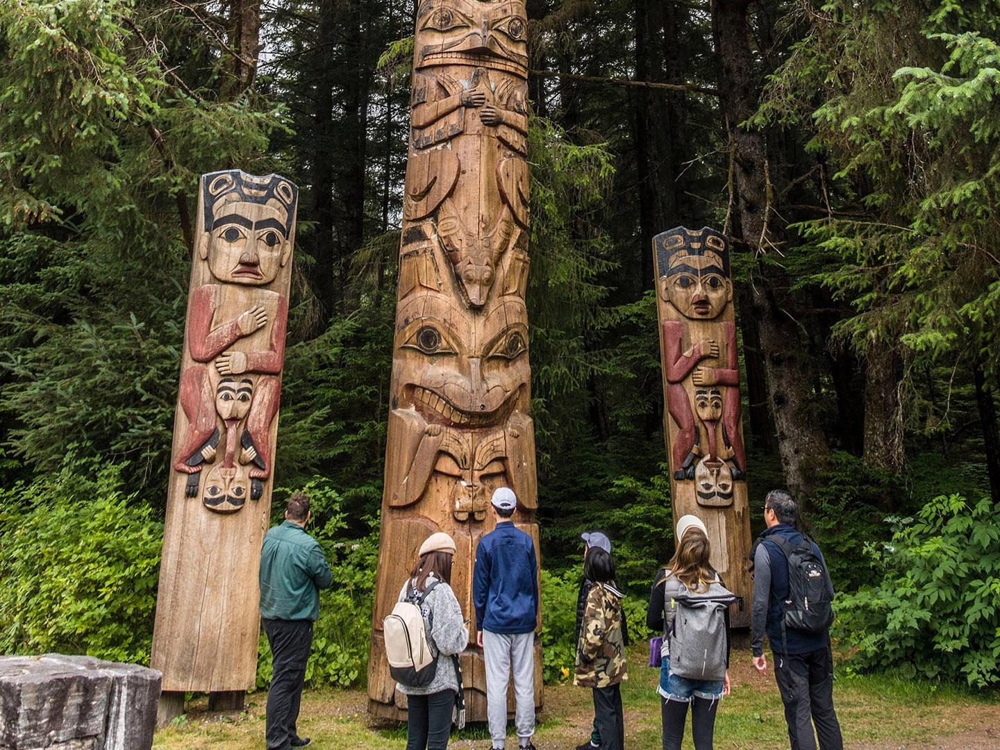 Viewing totem poles in Sitka National Historical Park, Alaska Viewing totem poles in Sitka National Historical Park, Alaska