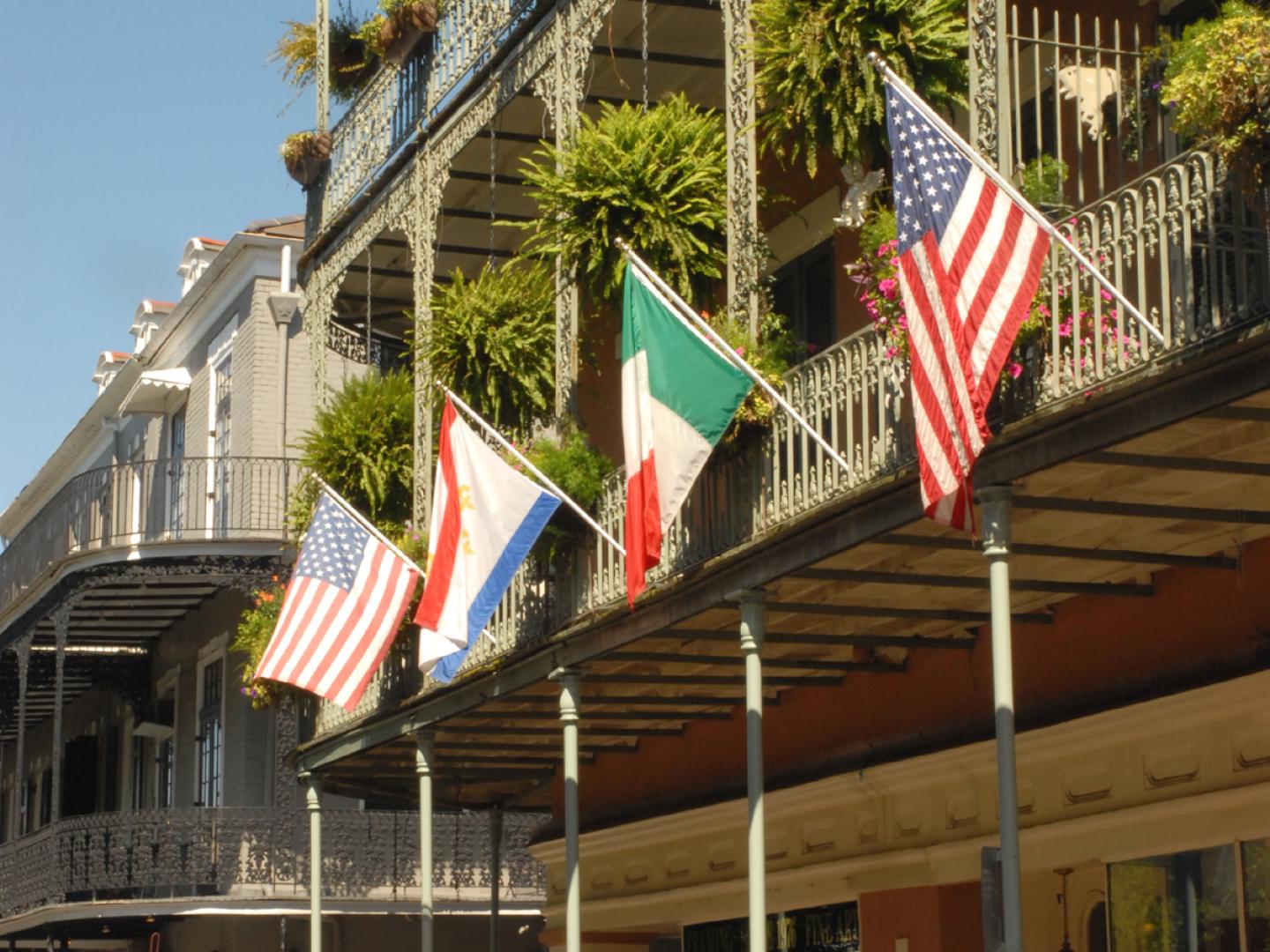 Flags hanging from the balconies in the French Quarter in New Orleans, Louisiana Flags hanging from the balconies in the French Quarter in New Orleans, Louisiana