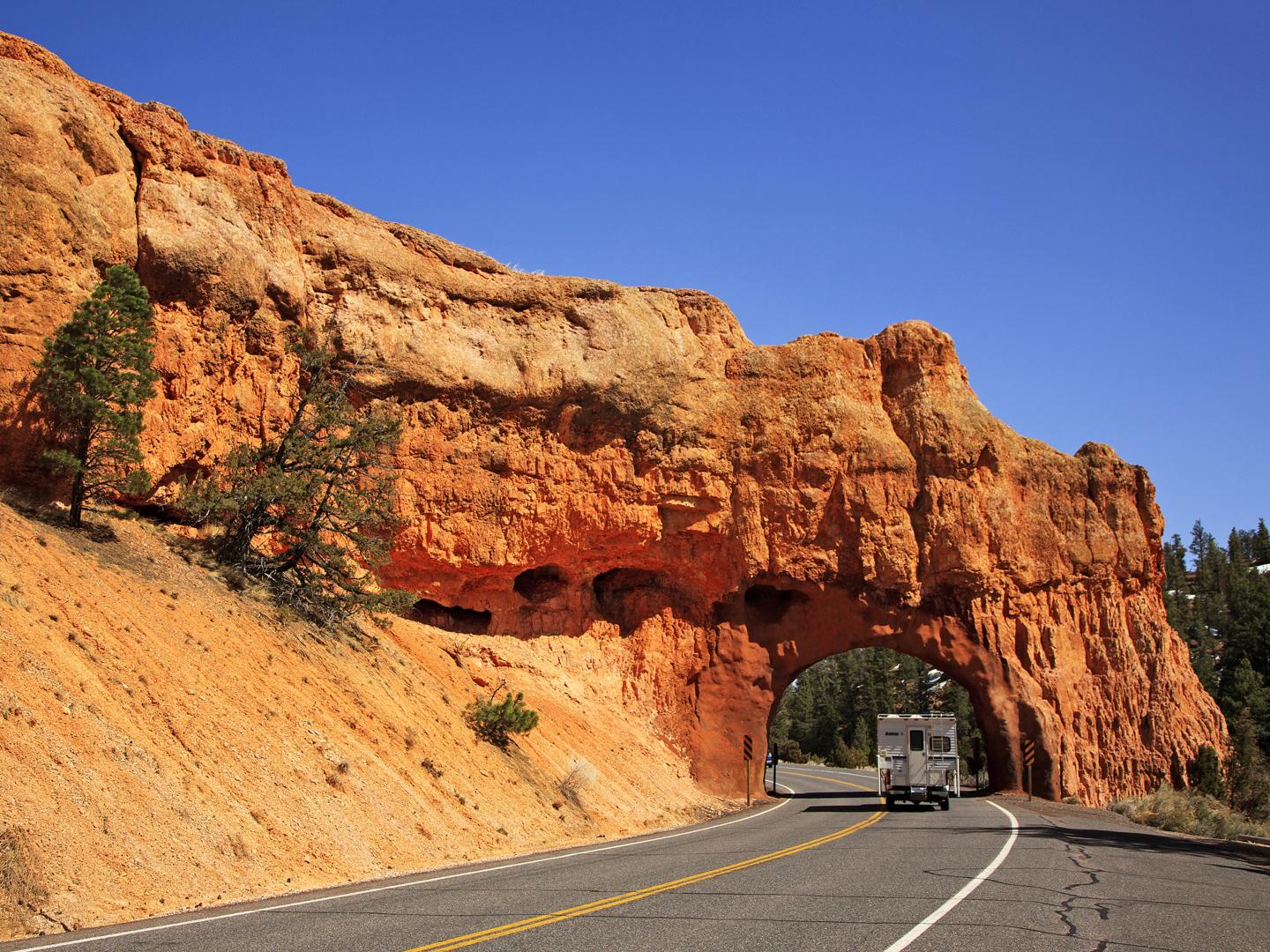 Crossing under a tunnel carved into the red rock along Scenic Byway 12 in Utah Crossing under a tunnel carved into the red rock along Scenic Byway 12 in Utah