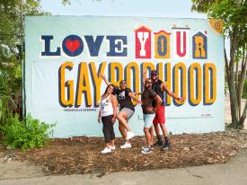 Friends posing in front of a mural in St. Petersburg, Florida