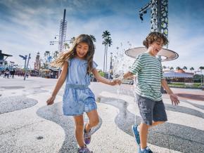 Enfants tout sourires jouant dans une aire de jeux d’eau Enfants tout sourires jouant dans une aire de jeux d’eau