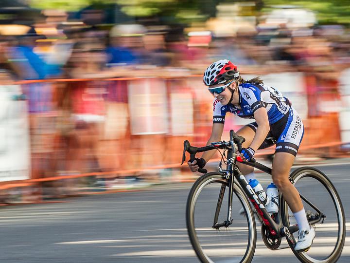 Crowds cheering from the sidelines as cyclists race at the Twilight Criterium Crowds cheering from the sidelines as cyclists race at the Twilight Criterium