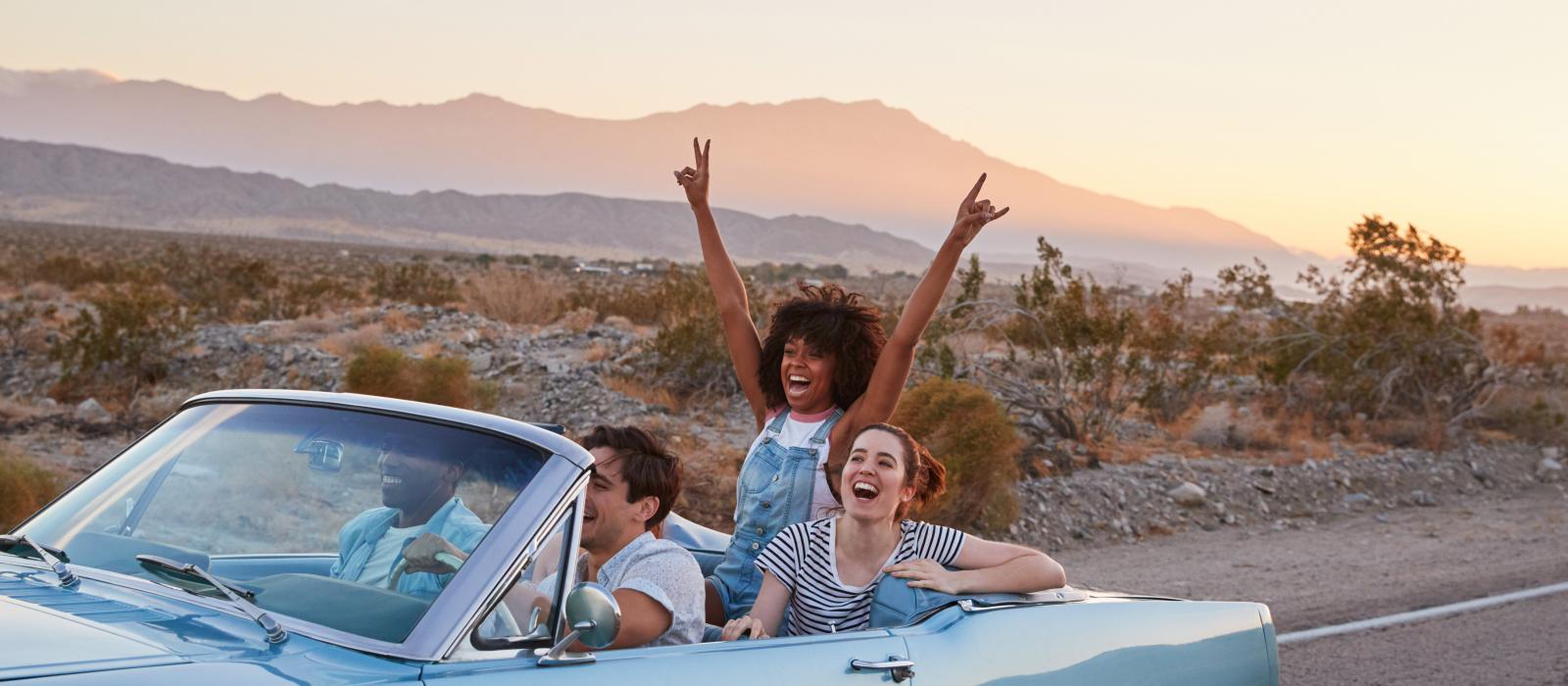 A group of friends cruising down a scenic U.S. highway on a road trip A group of friends cruising down a scenic U.S. highway on a road trip